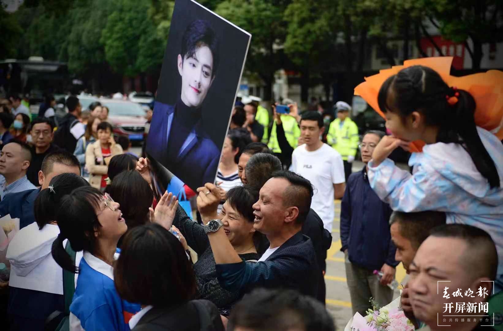 考生们走出考场 学生家长拿着海报