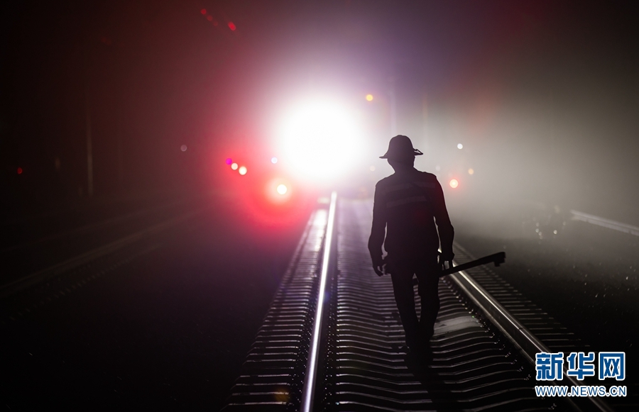 一名铁路职工手拿道尺 前往精调作业的线路 。新华网发 何俊云 摄).jpg