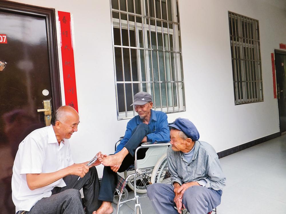 李桂科（左）在为患者修剪趾甲