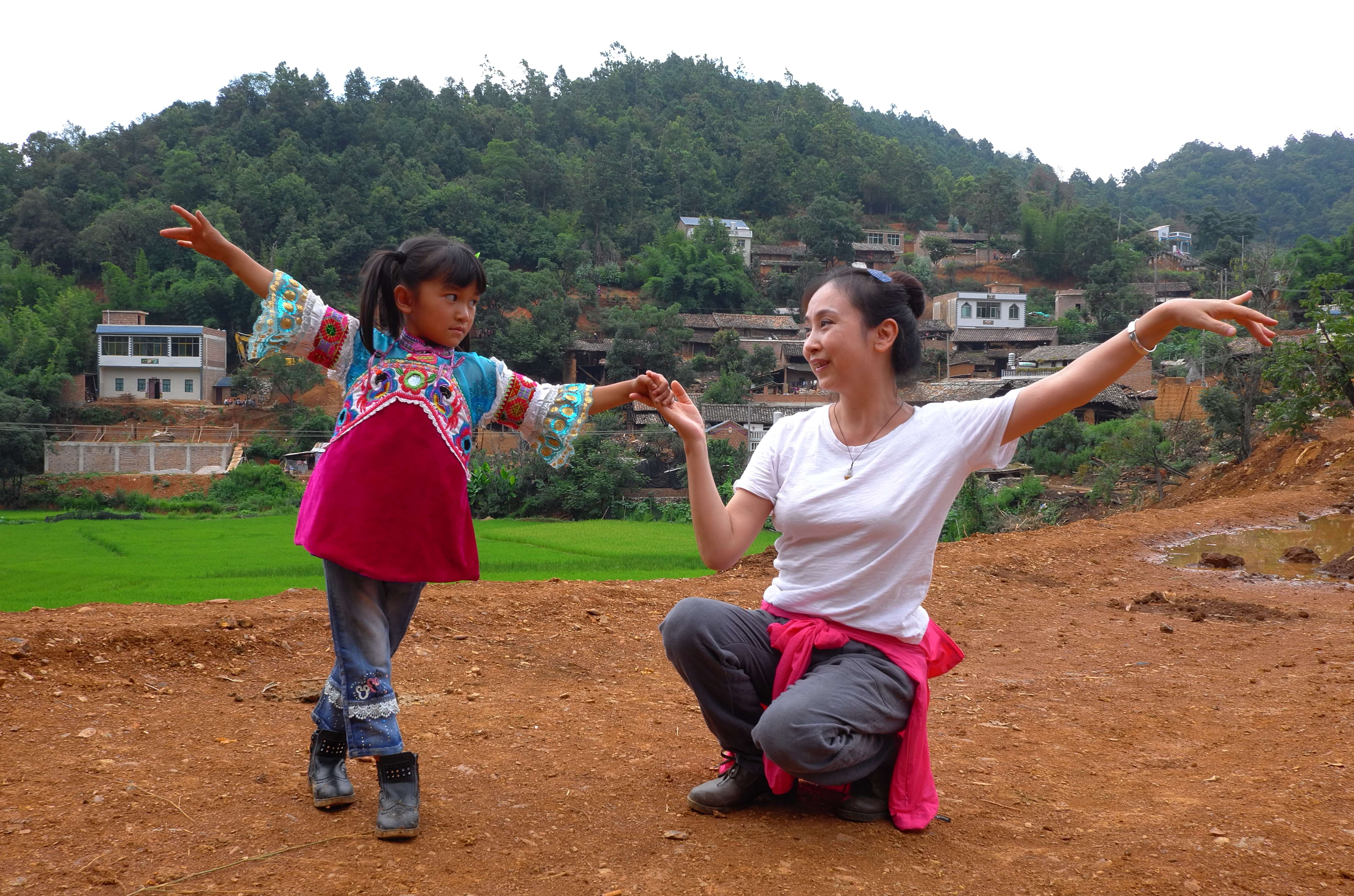 张萍在那夺村还未硬化的路面上教孩子跳舞 受访者供图.jpg