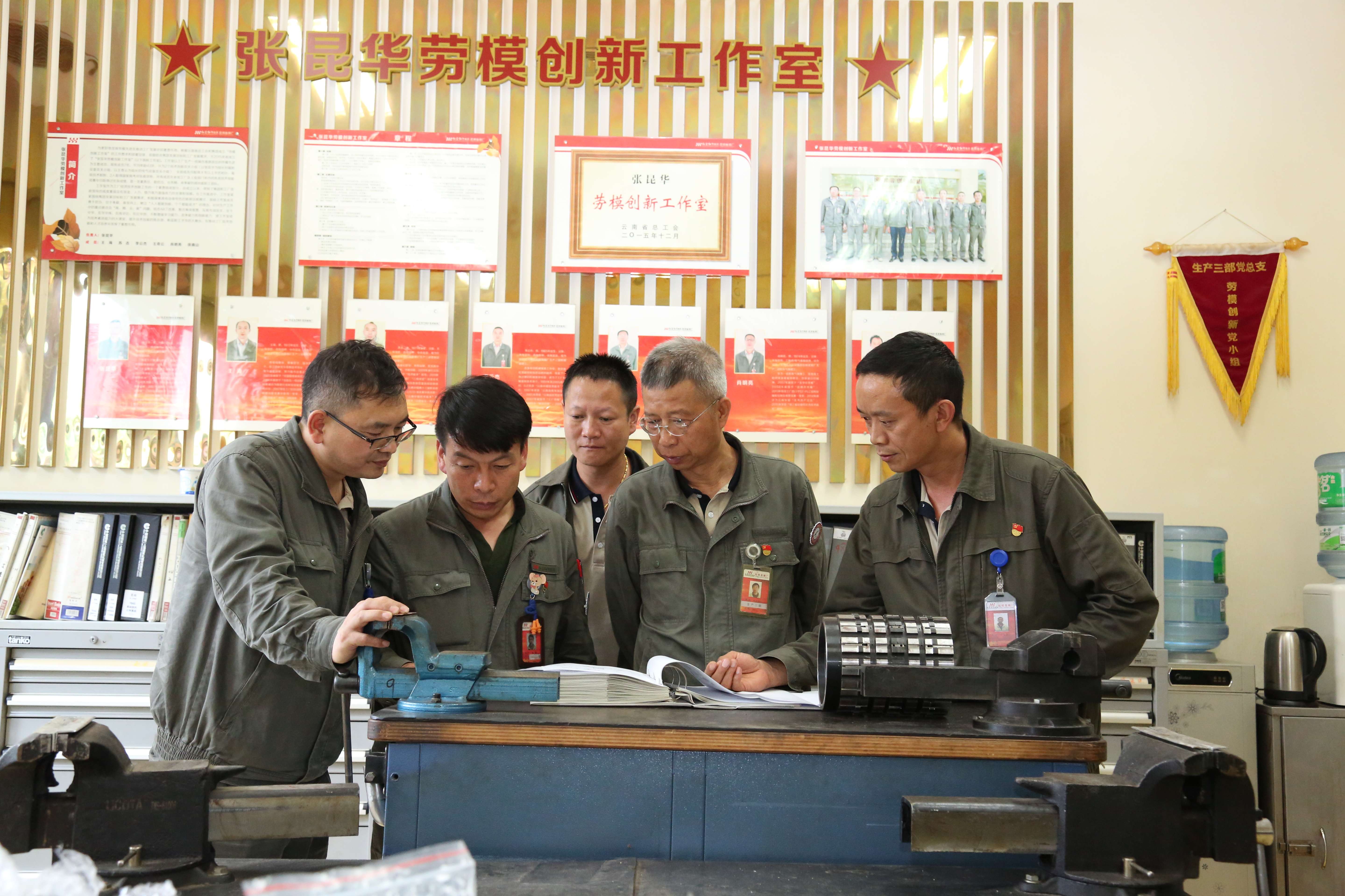 昆烟劳模创新工作室中修组修理工张昆华（右二）与同事讨论交流设备技术.jpg