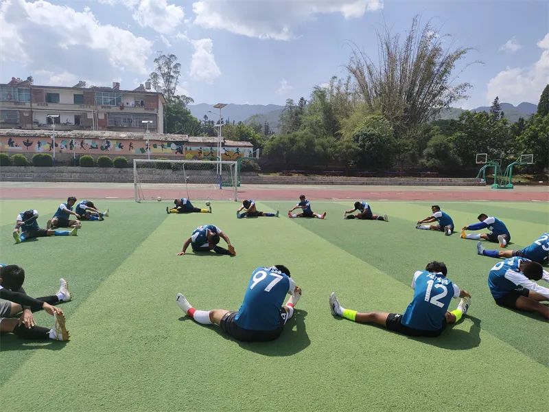到沧源县民族中学踢比赛的龙乃足球队正在进行热身活动.jpg