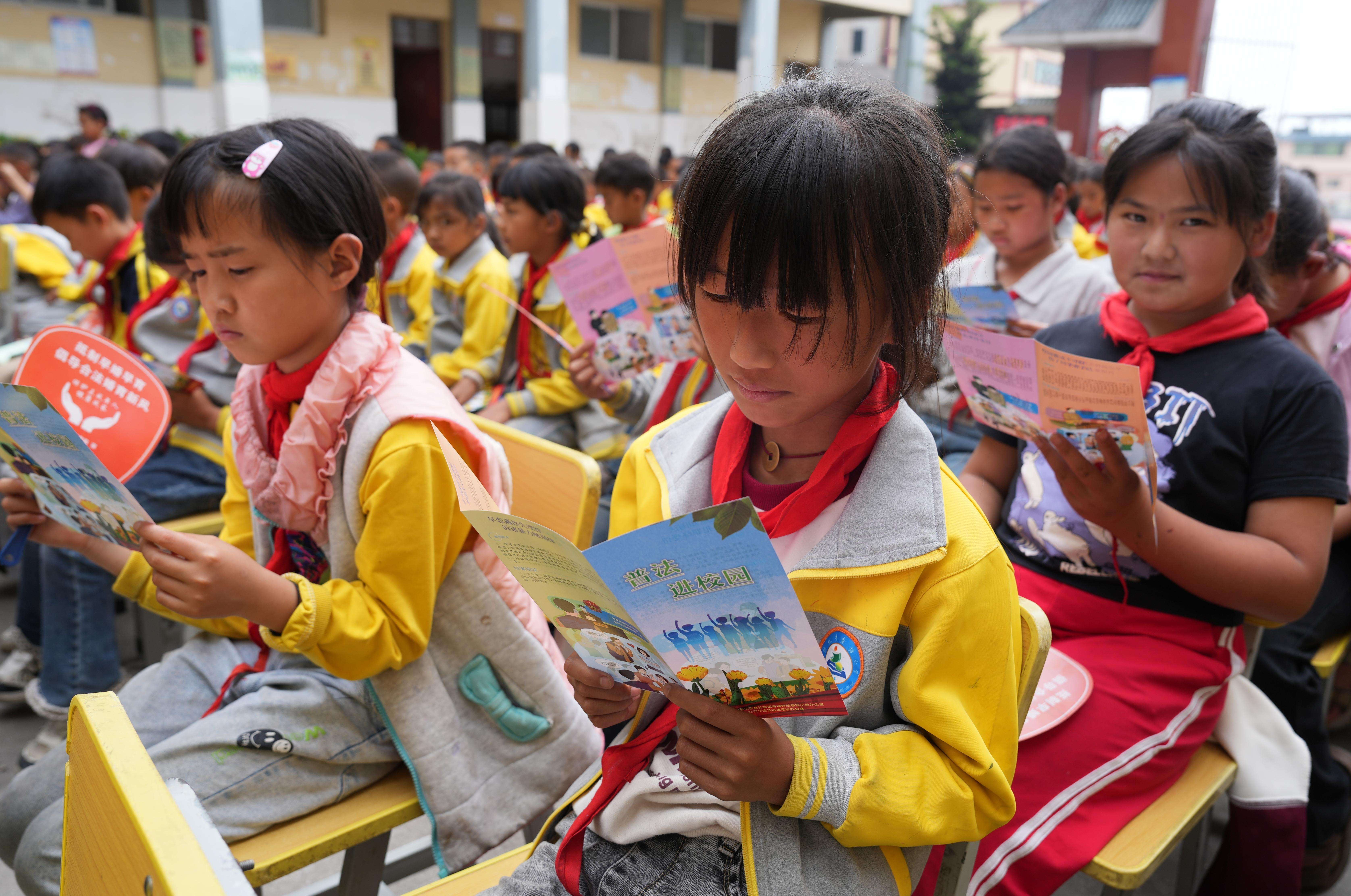 妈卡波村委会鱼塘小学的小学生在阅读法治宣传折页（胡艳辉 摄）DSC04963.JPG
