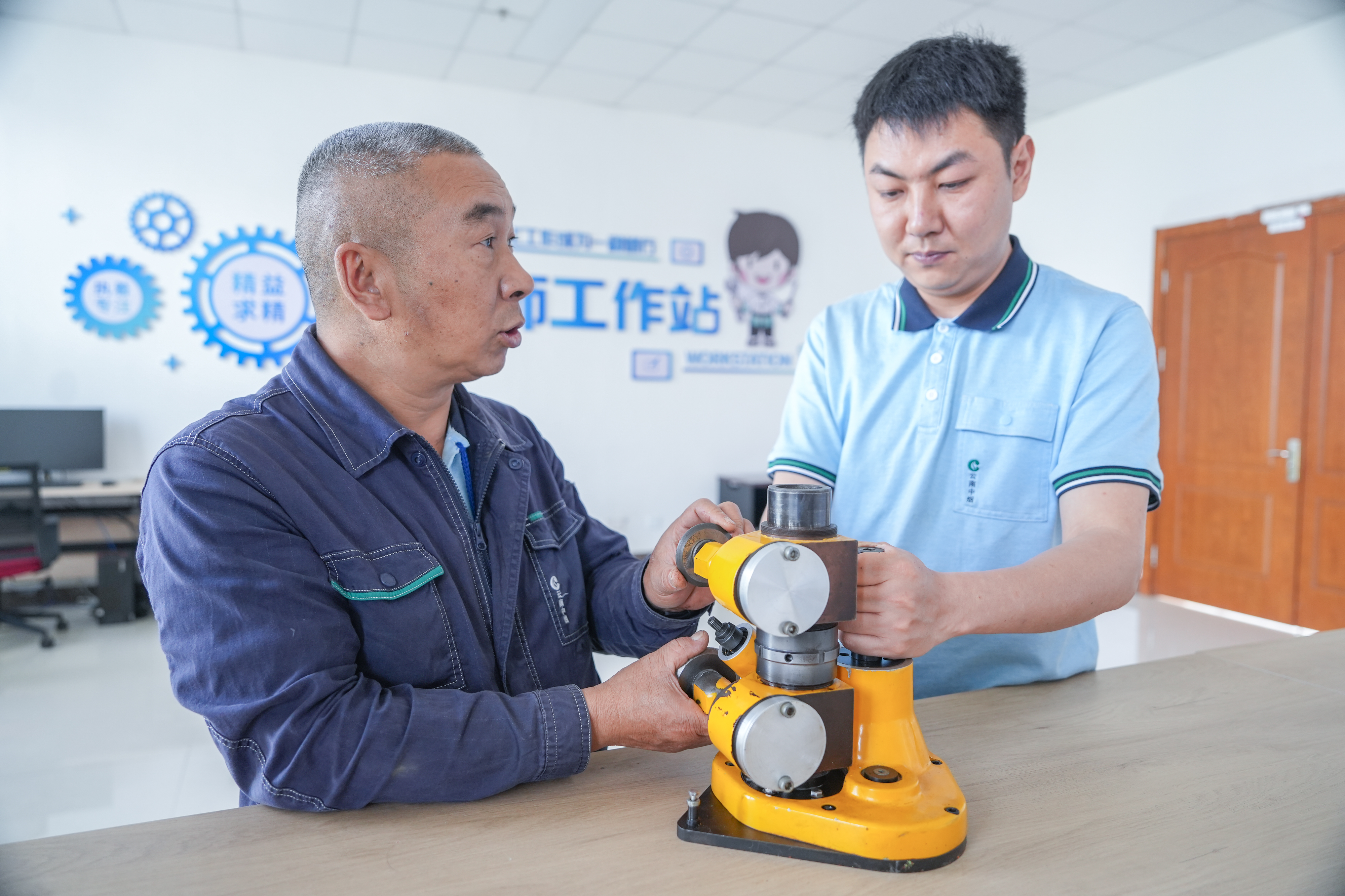 谭文昌在工作站里和关堡方交流维修经验.jpg