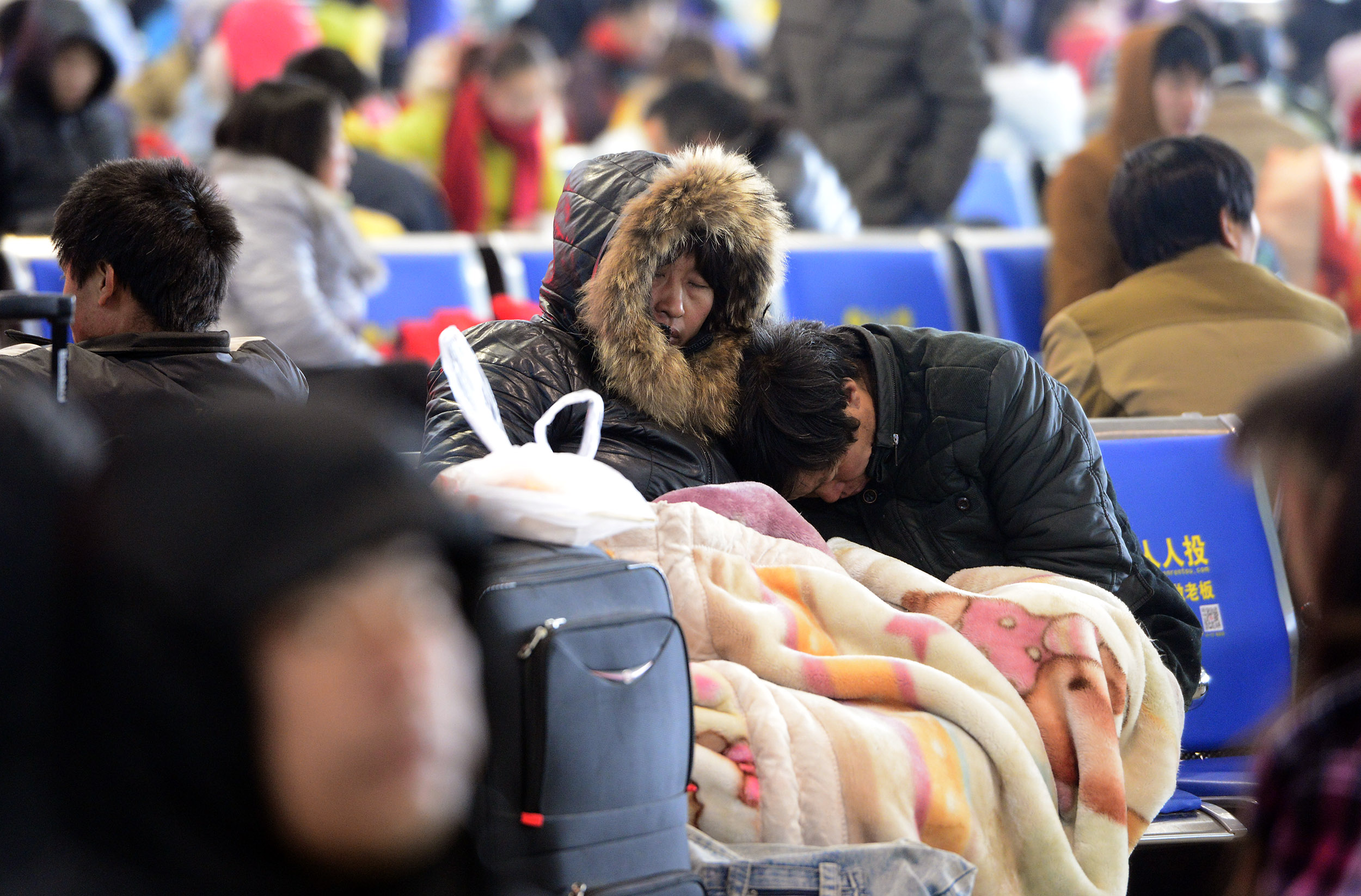 春运首日遇最冷天气，火车站候车大厅旅客盖着毛毯候车 本报记者 翟剑 摄