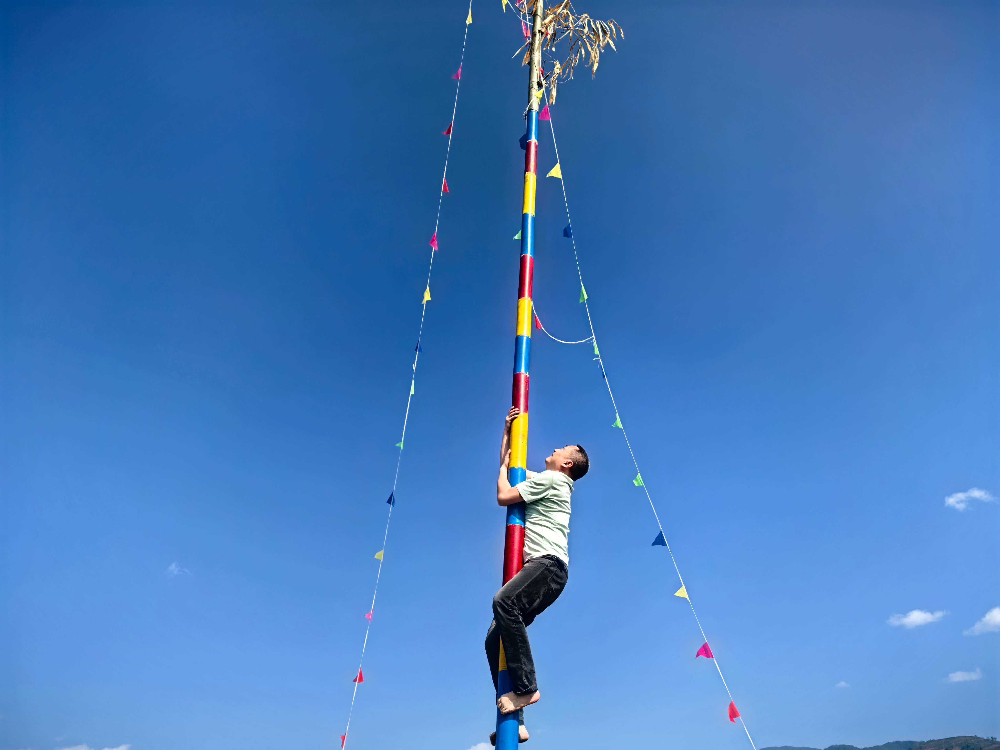 游客参与爬花杆比赛.jpg