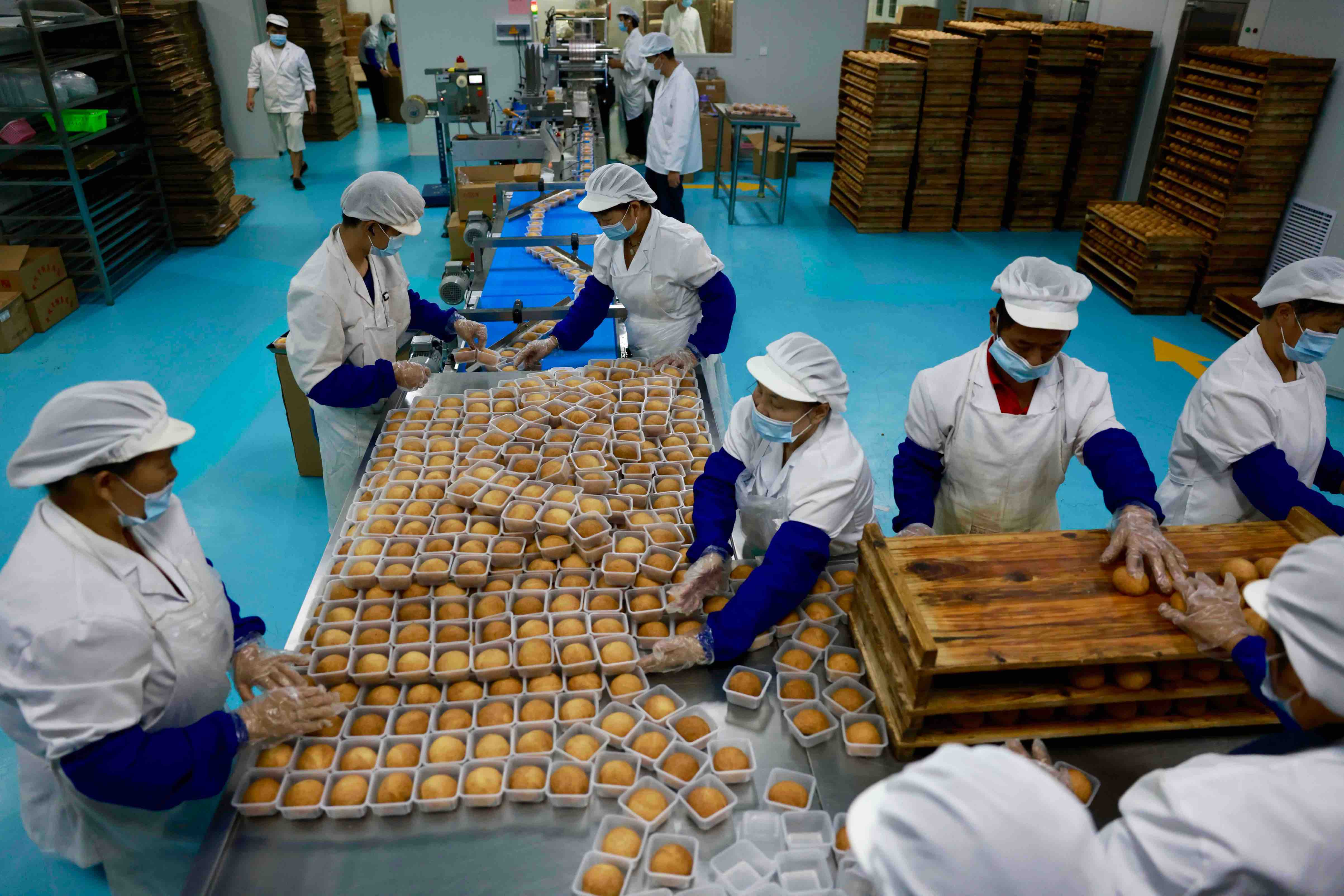 标准化分装工序,以洁净规范的生产流程守护月饼品质。摄于2026年,九九物业管理有限公司糕点制作车间
