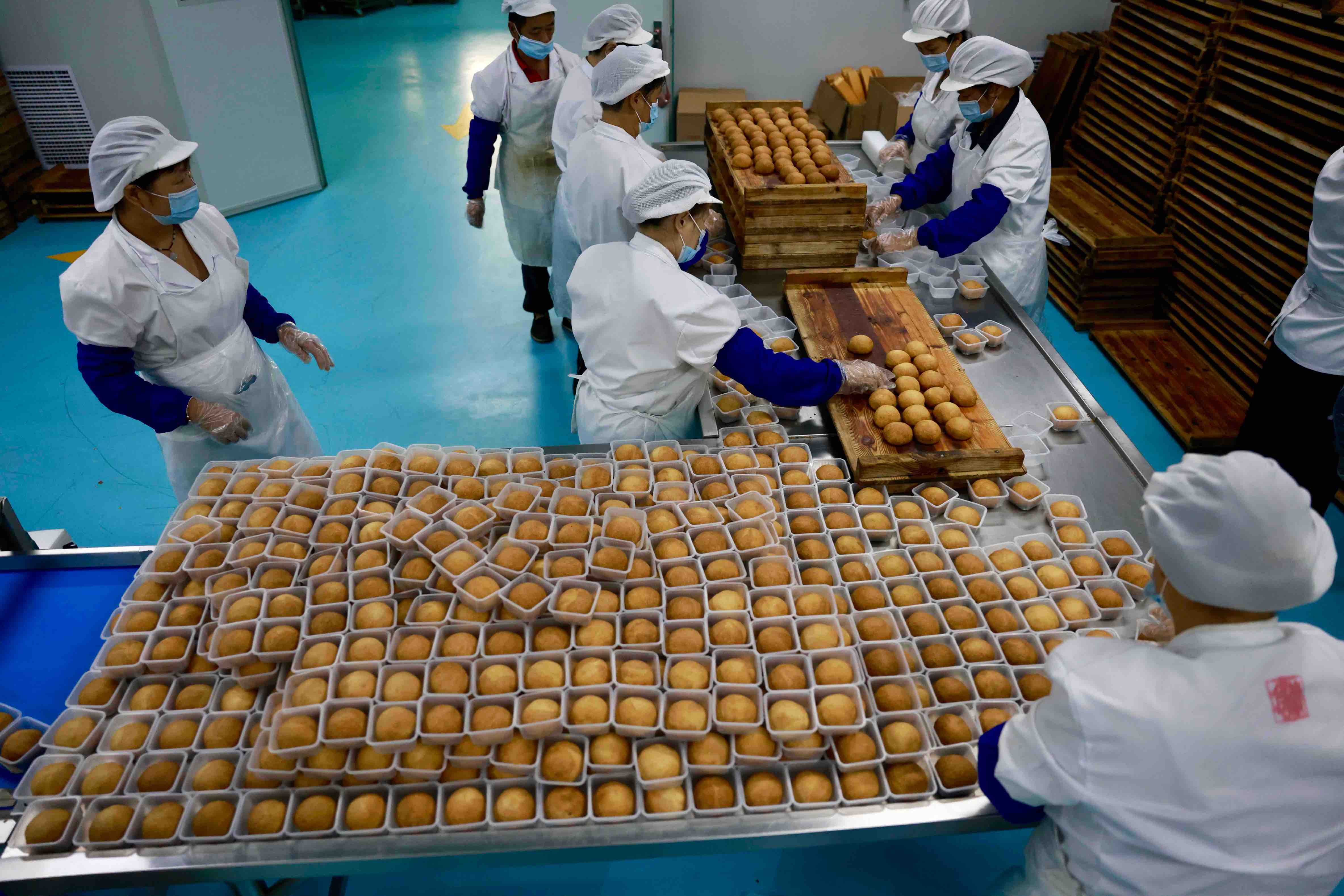 工作人员对月饼进行托盒分装。摄于2026年,九九物业管理有限公司糕点制作车间
